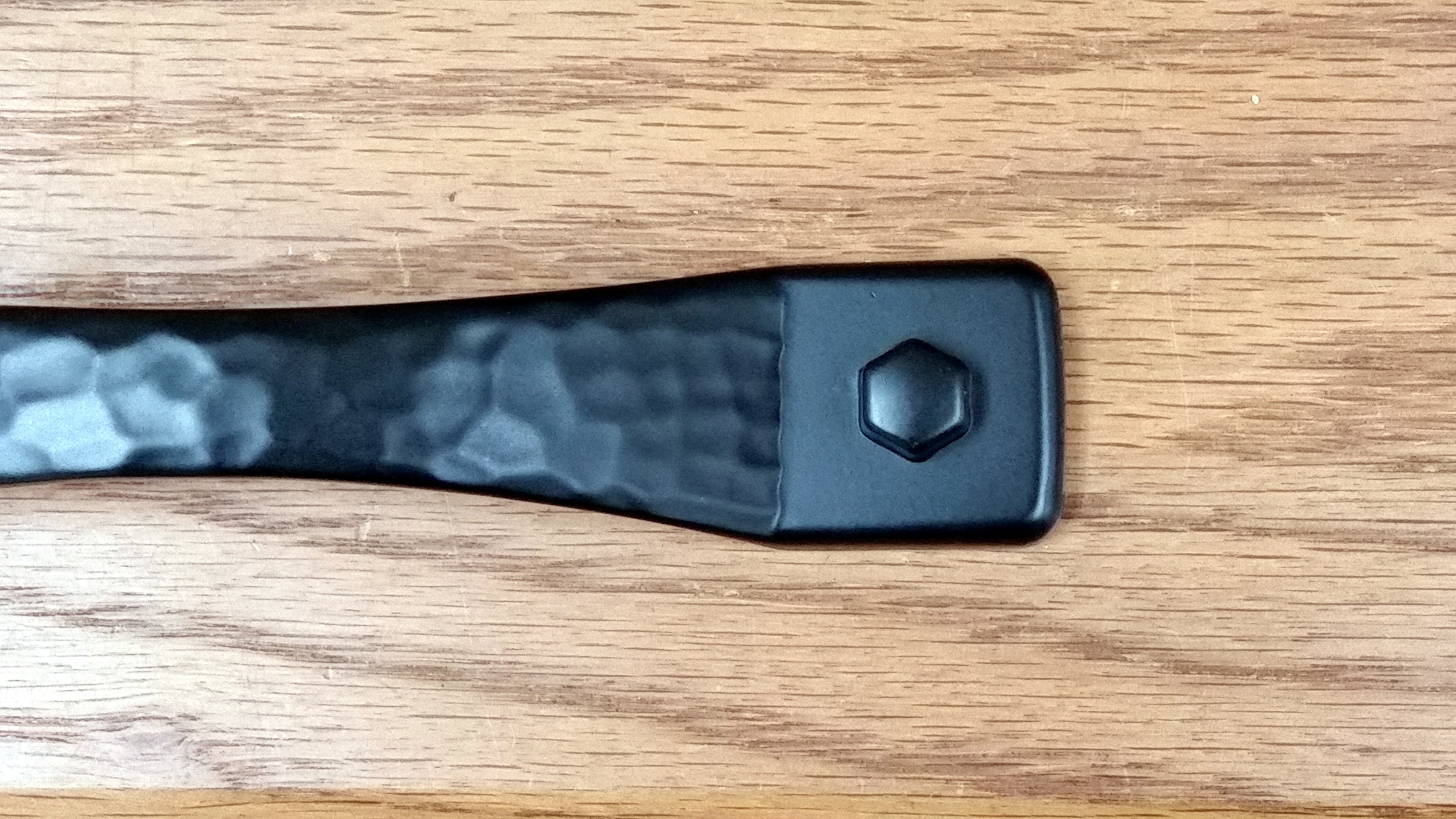 Rustic hammered drawer pull in matte black finish, featuring a textured design and hexagonal base.
