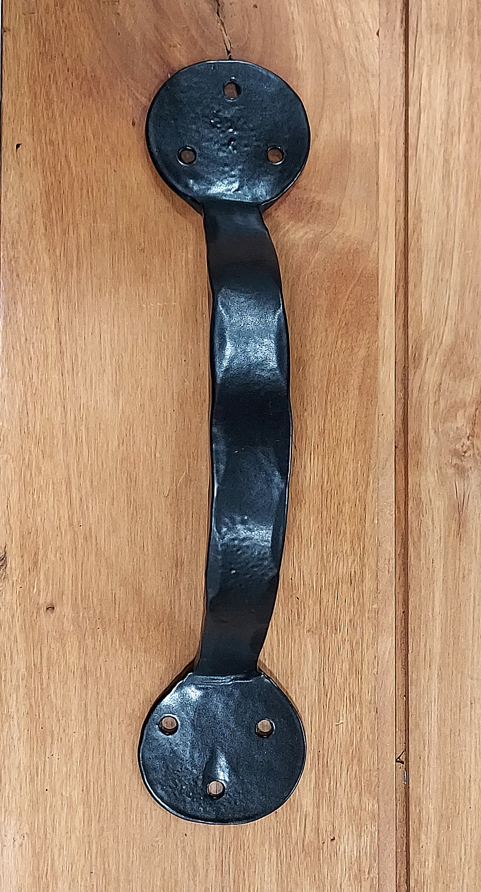 Bean style door handle with a wavy design, available in various sizes and finishes, includes rustic head screws.