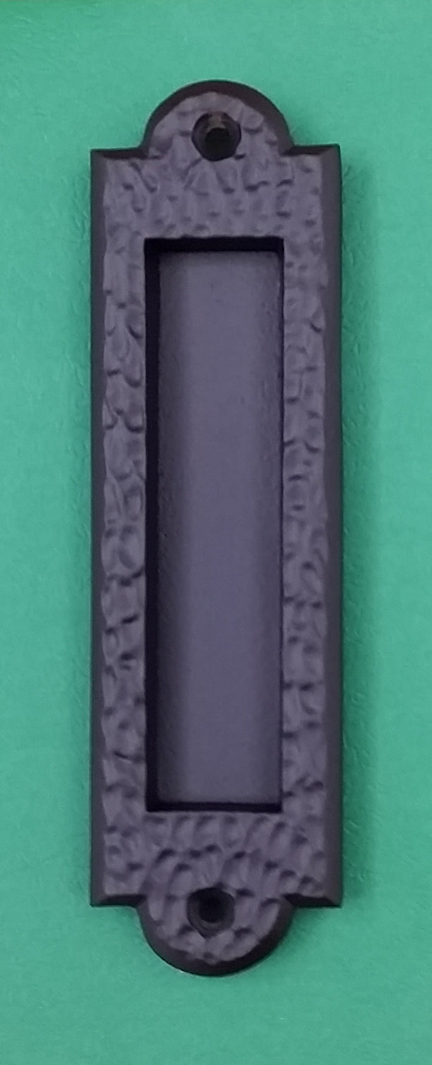 Flush pull handle with a distressed matte bronze finish, featuring a pitted texture, available in multiple sizes.