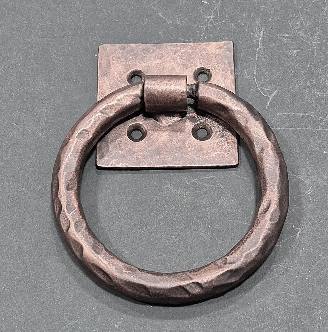 Distressed 4-inch ring pull with a hammered back plate, available in multiple finishes, sold individually.