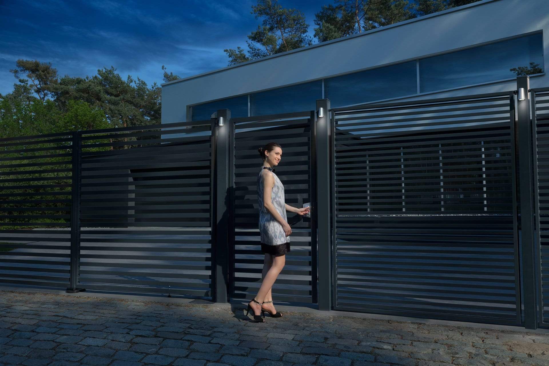 Stainless steel 90° 2-way adjustable bearing gate hinges in a modern outdoor setting with a woman by a gate.