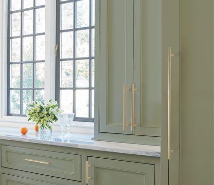 Elegant cabinet pulls in golden champagne finish, 7-9/16" center to center, enhancing modern kitchen cabinetry.