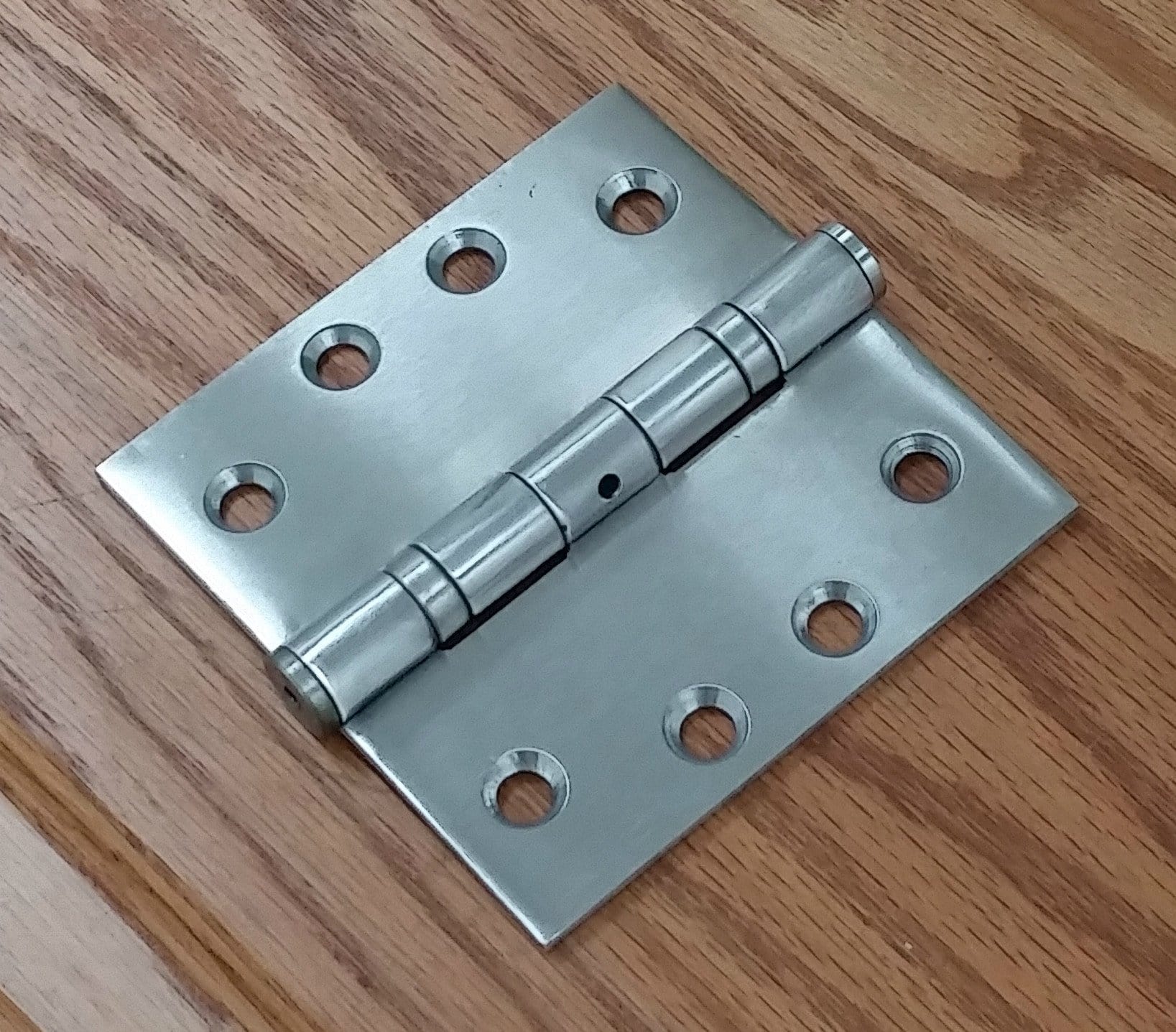Commercial ball bearing door hinge, 4 inches square, available in multiple finishes, sold in pairs for durability.