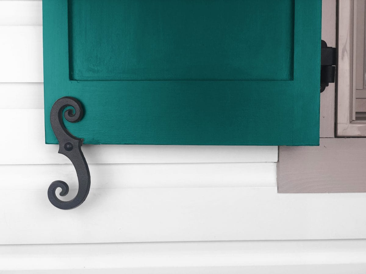 Faux shutter dogs in black powder-coated cast iron, 6-3/4 inches, featuring a beveled smooth scroll design.