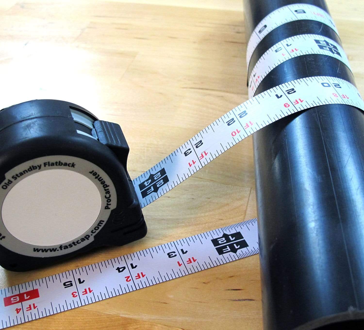 Procarpenter Flatback Flexible Tape Measure displayed on a wooden surface, measuring a black pipe.