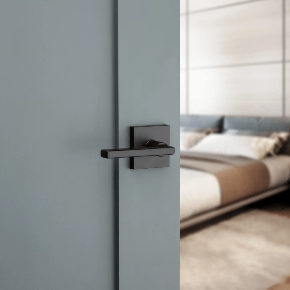Kwikset Halifax square non-locking passage door lever in iron black finish, ideal for residential use.