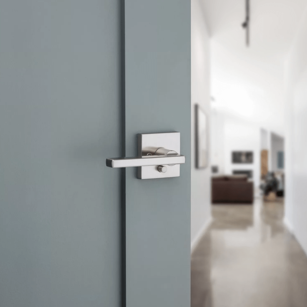 Kwikset Halifax square privacy door lever in satin nickel finish, designed for residential use, shown on a modern door.