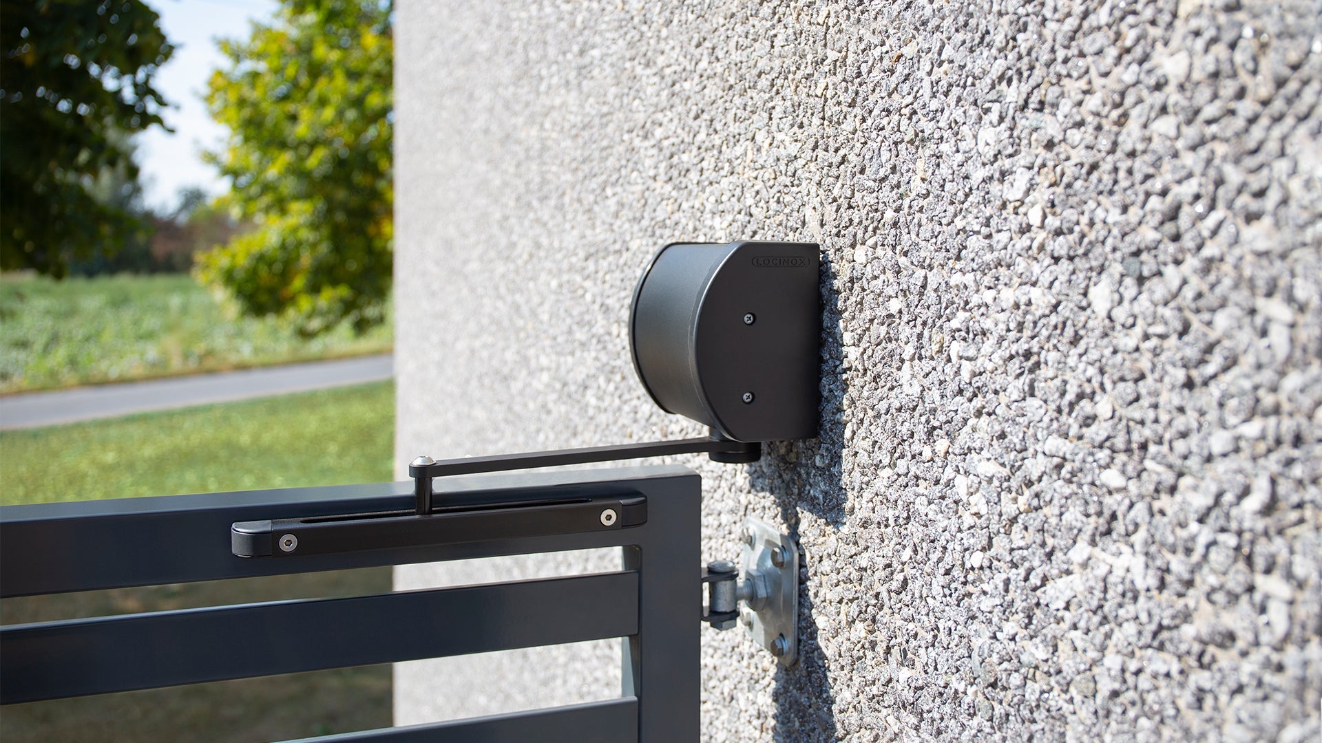 Compact Locinox Panther gate closer in black finish, designed for gates up to 330 lbs, mounted on a textured wall.
