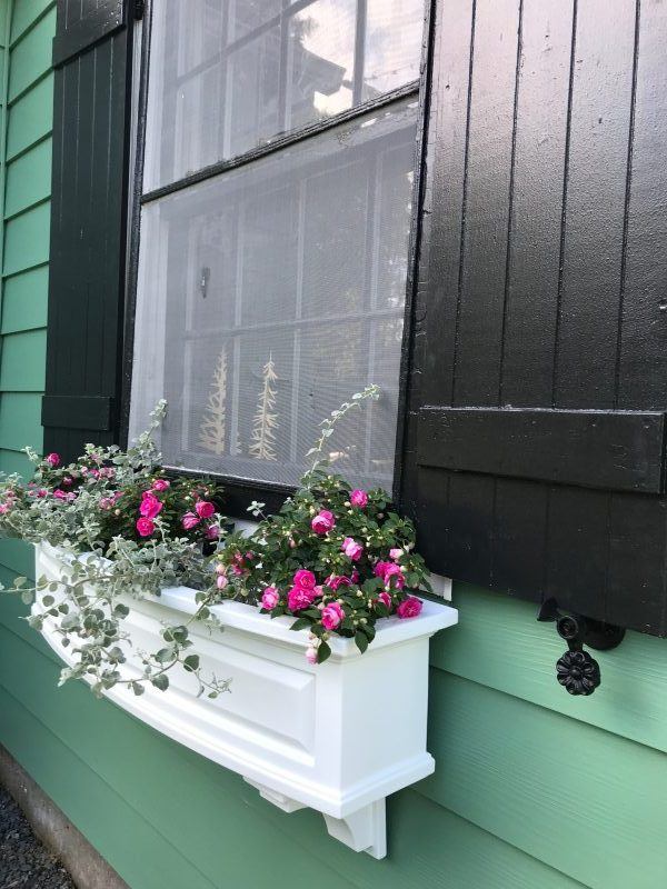 Black powder-coated cast iron shutter dogs in flower design, 4-1/2 inches, sold in pairs for securing shutters.