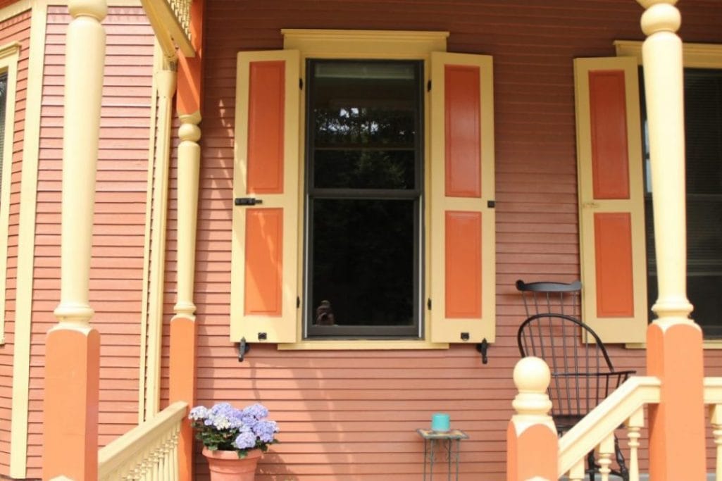 Black powder-coated cast iron shutter dogs in a pair, designed for securing window shutters, 6-1/4 inches long.
