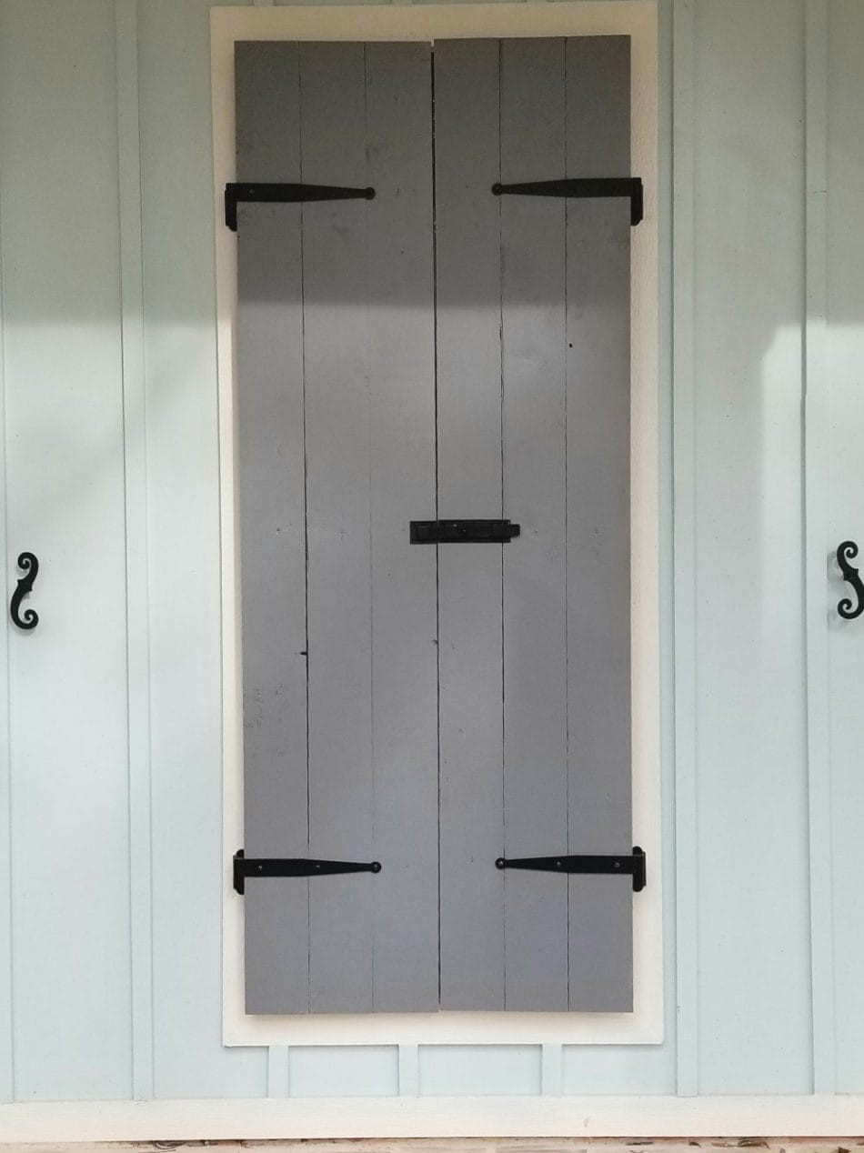 Stainless steel shutter dogs with a black textured powder coat, 6-3/4 inches, sold in pairs for securing shutters.