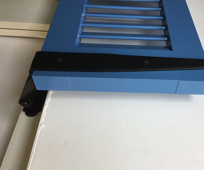Black powder-coated strap hinge for shutters, 12 inches long with a 1-1/2 inch offset, showcasing a circle tip design.
