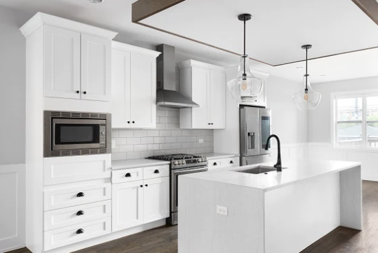 A modern white kitchen with matte black hardware.