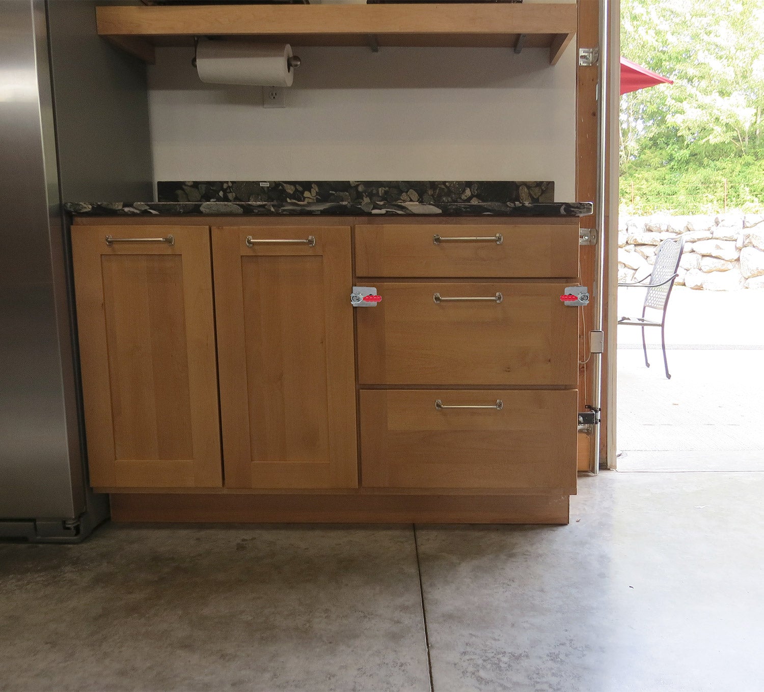 Drawer front clamps sold in pairs, securely holding drawer fronts on a wooden cabinet in a workshop setting.