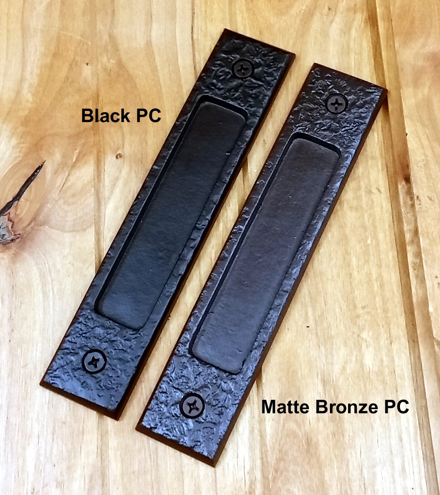 Large flush pull barn door handles in black and matte bronze finishes, featuring a textured design for easy grip.