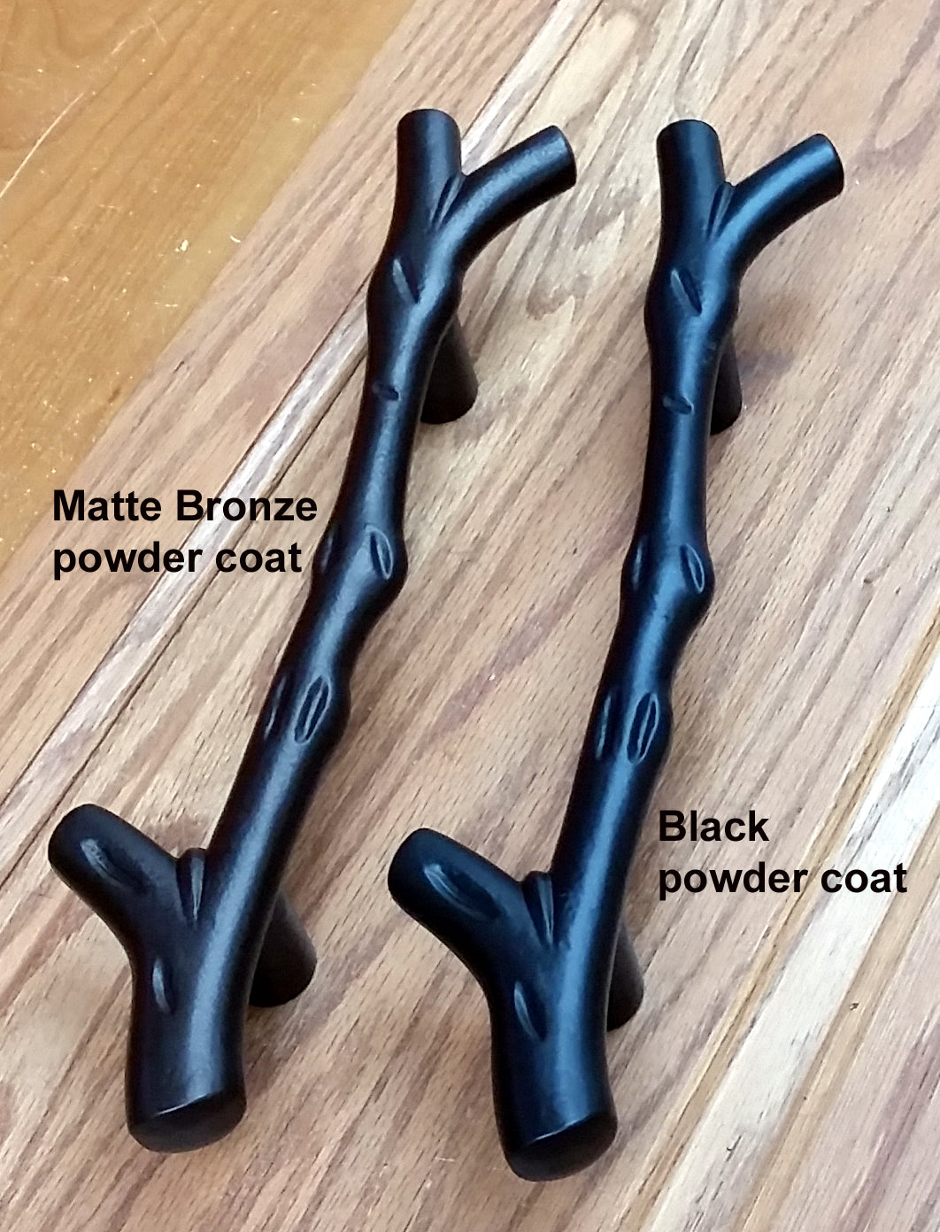 Large tree branch barn door handle and textured flush pull set in matte bronze and black finishes for rustic decor.