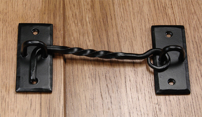 Forged twisted iron cabin hook with a black finish, ideal for securing doors or gates. Sold individually.