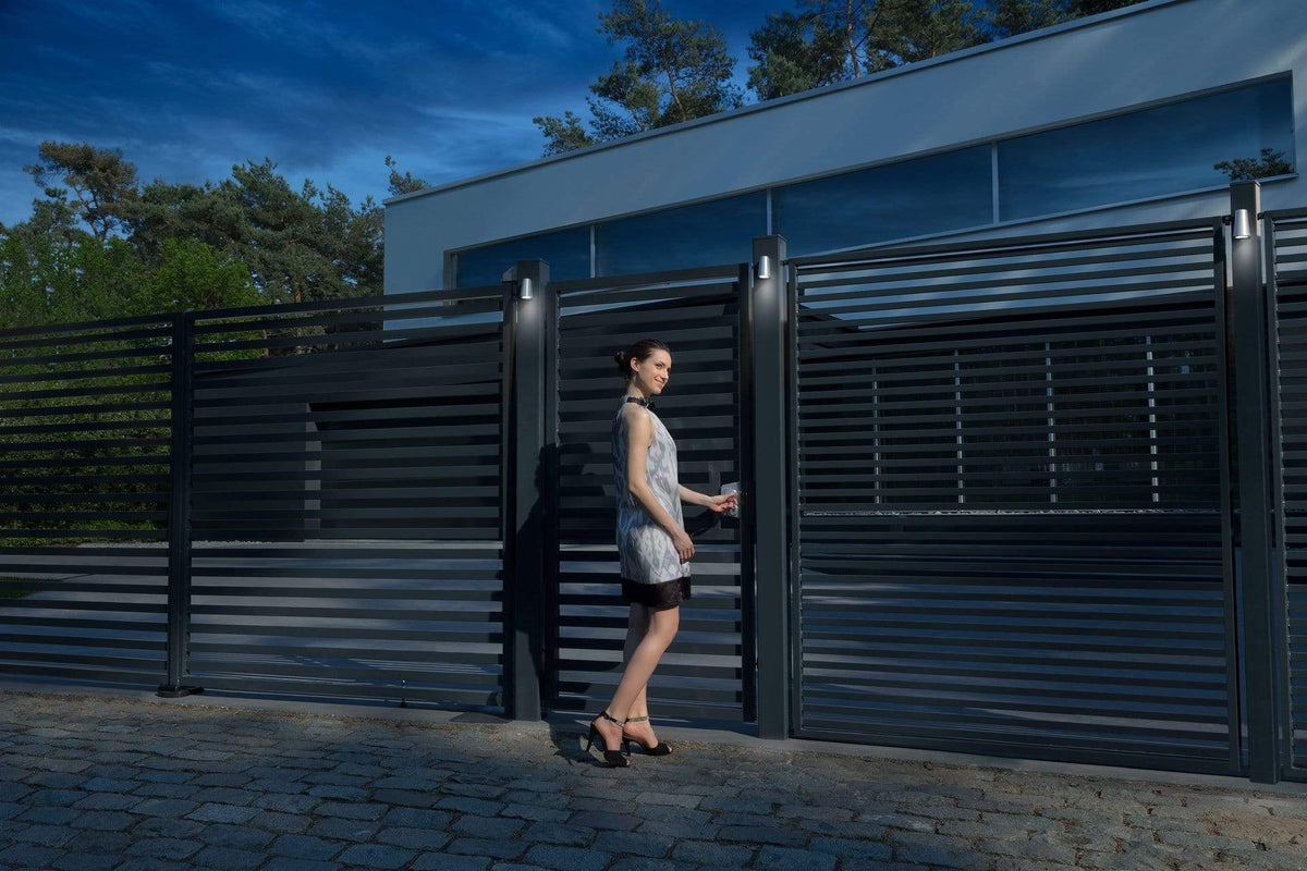 Stainless steel 90° 2-way adjustable bearing gate hinges in a modern outdoor setting with a woman by a gate.