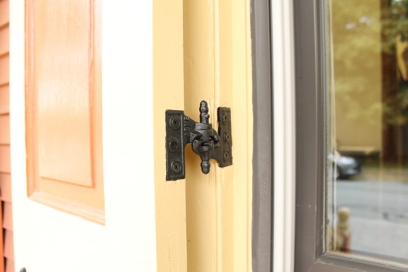 Acme mortise shutter hinges in cast iron with WeatherWright coating, shown installed on a door frame.