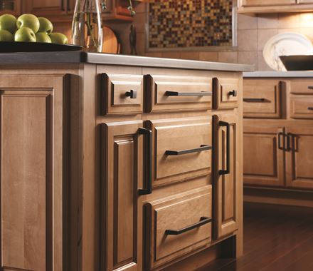 Blackrock Series square cabinet knob in black bronze finish, 1-3/16 inch, displayed on a wooden kitchen cabinet.