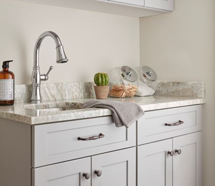 Edona Series 1-1/4 inch cabinet knobs in various finishes displayed on a stylish kitchen cabinet.