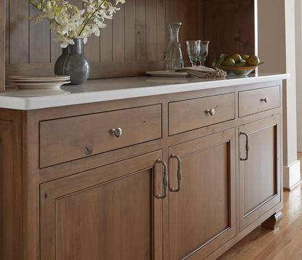 Edona series cabinet knobs in 1-1/4 inch size displayed on a wooden cabinet with a light countertop and decor.