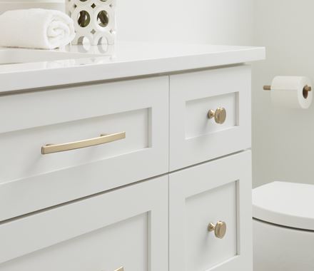 Cabinet knob from the Oberon Series in golden champagne finish, 1-3/8 inch, displayed on a white cabinet.