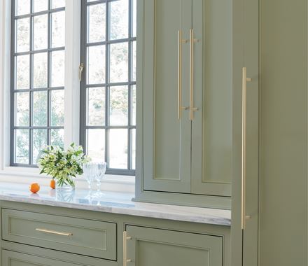 Elegant golden champagne bar pull cabinet handles, 5-1/16" center to center, enhancing modern kitchen cabinetry.