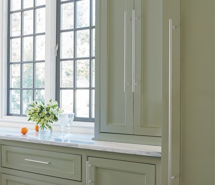 Sleek stainless steel cabinet pulls in bar pull design, 5-1/16" center to center, enhancing modern kitchen cabinetry.