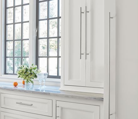 Sleek stainless steel cabinet pulls in a bar pull design, 5-1/16" center to center, enhancing modern kitchen cabinetry.