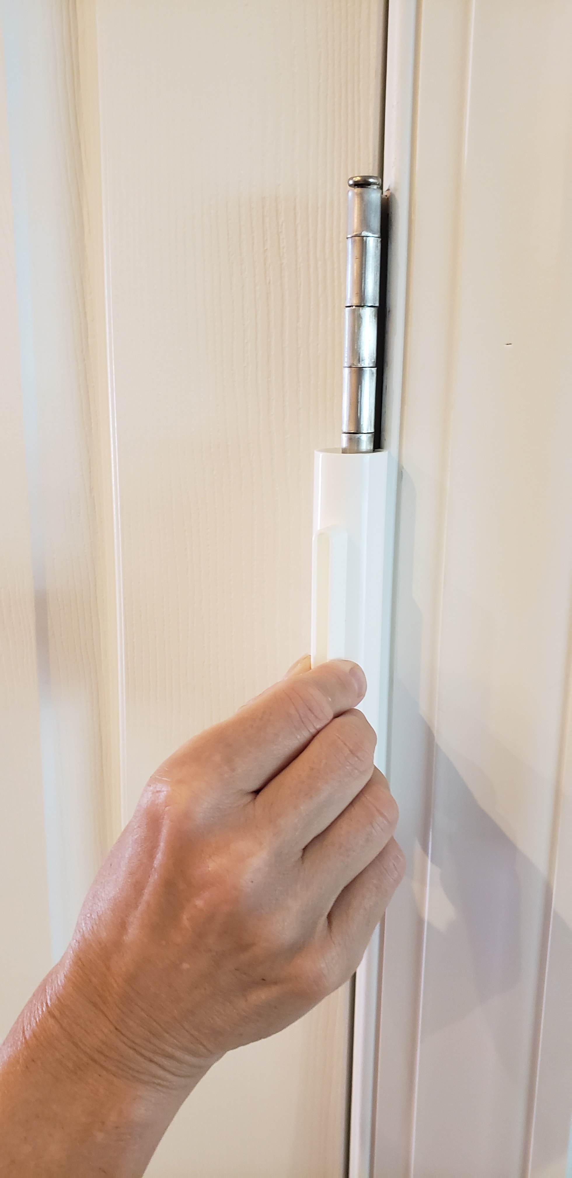 Hinge Hero door hinge lubrication tool being used on a door hinge for smooth operation and maintenance.