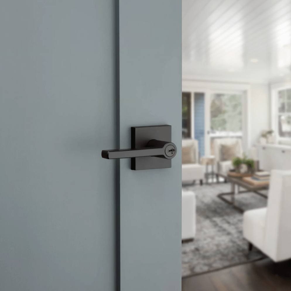 Kwikset Halifax square design entry door lever in iron black finish with SmartKey security, mounted on a door.