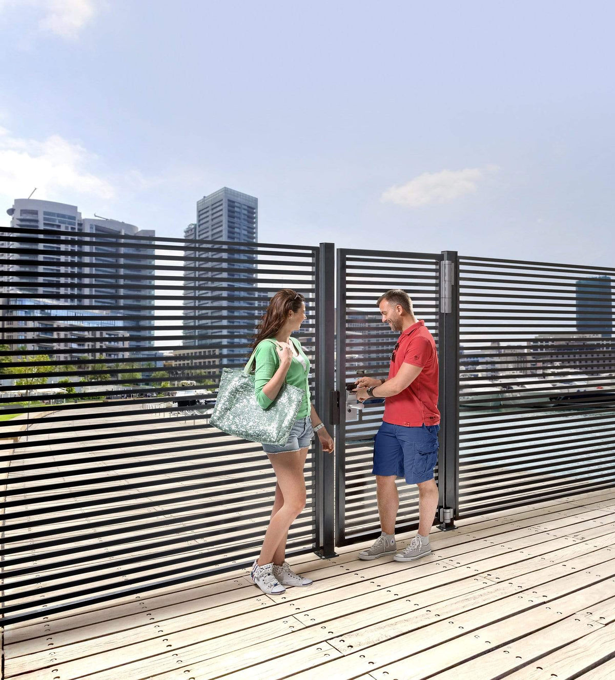 Two people interacting with a modern gate featuring Locinox Dino double bearing hinges, suitable for heavy gates.