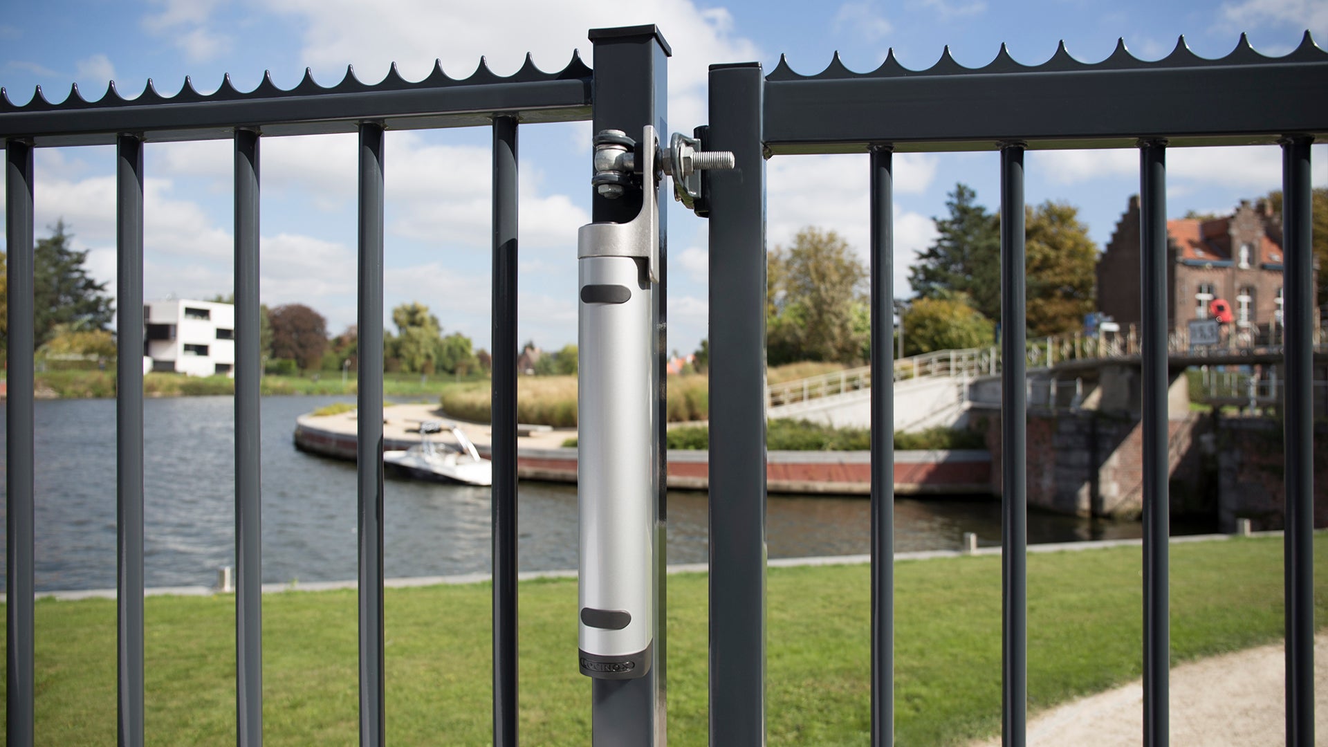 Aesthetical 180° gate closer mounted on a black metal gate, designed for gates up to 330 lbs, available in multiple finishes.