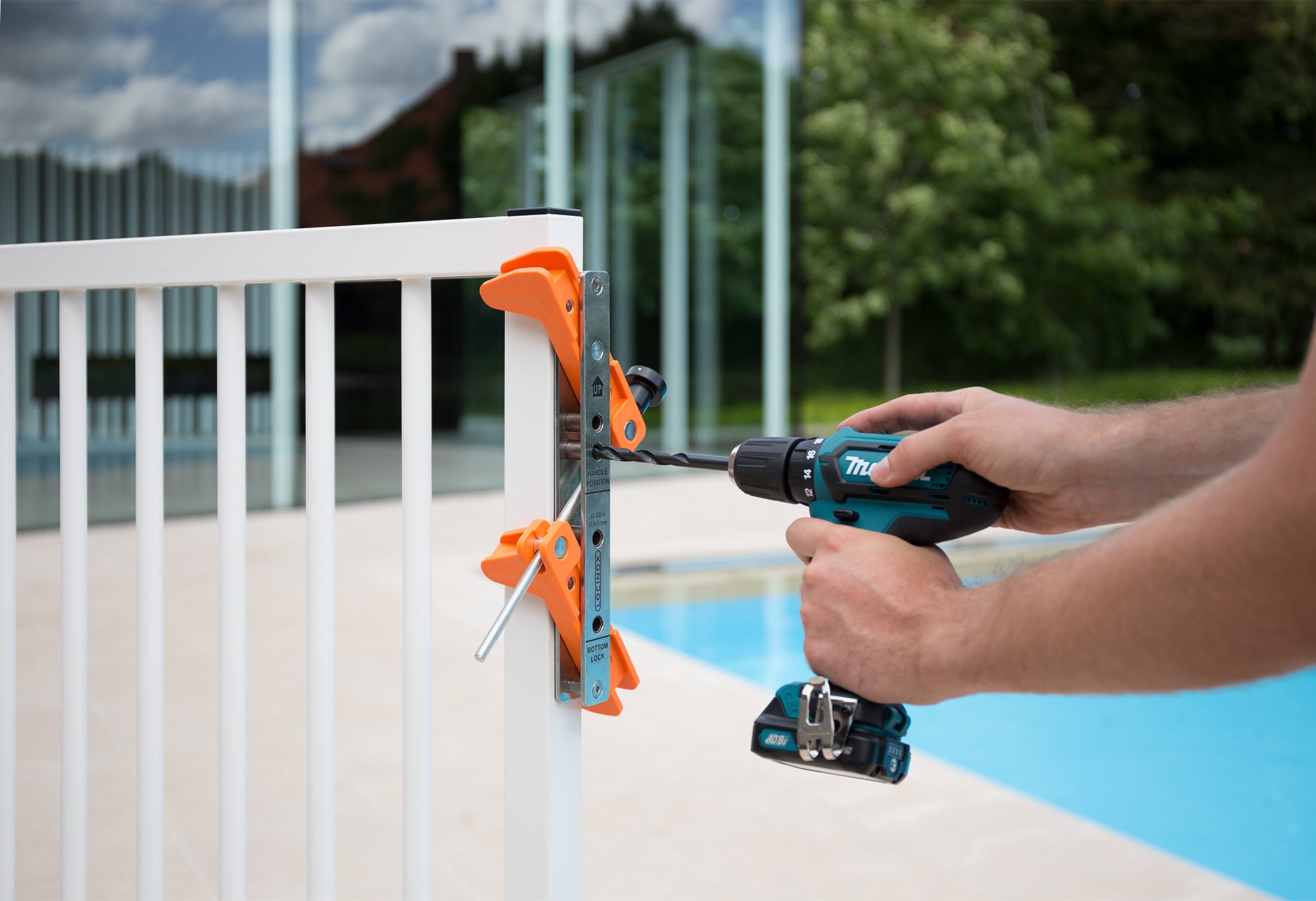 Locinox tool case with drilling jig for surface mounted locks, showing a person using a drill on a gate.