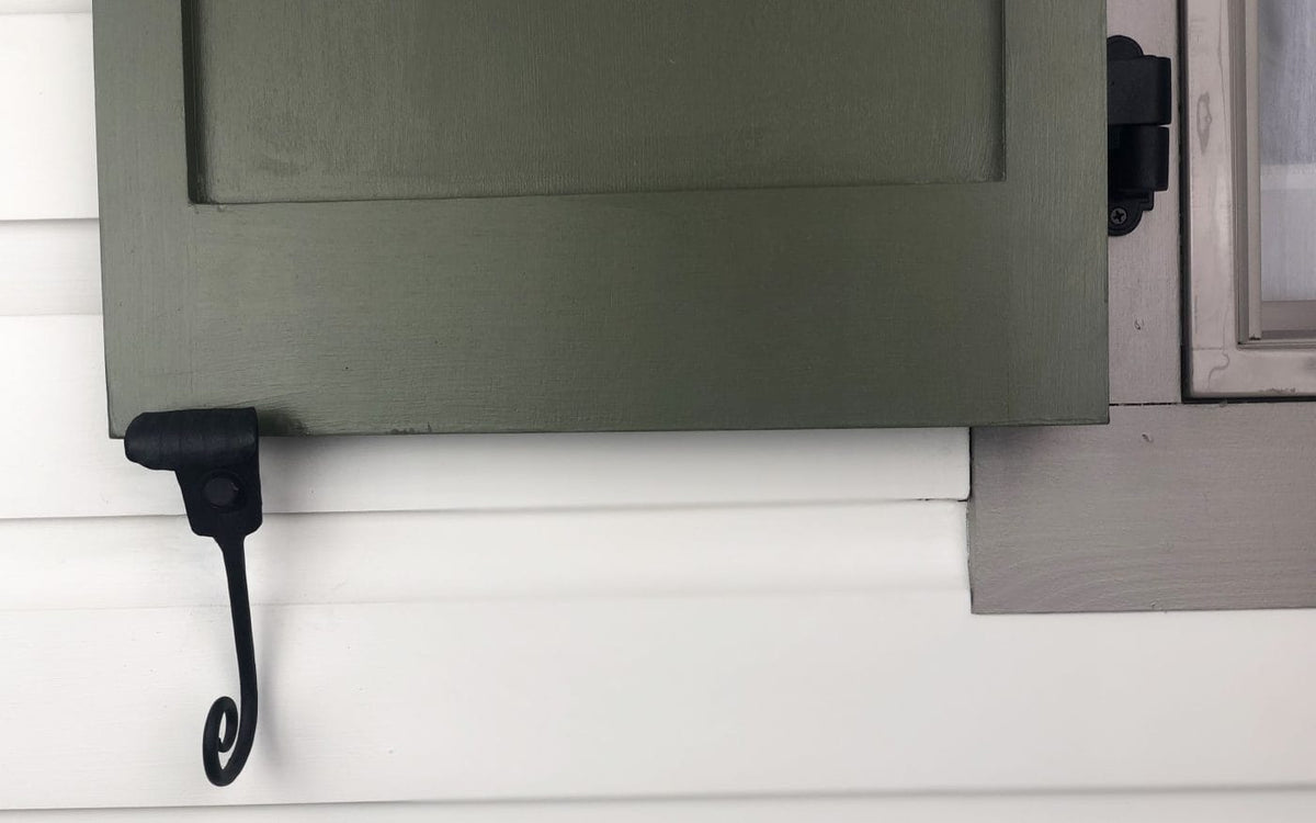 Black forged steel shutter dogs with a powder coat finish, designed for securing shutters, sold in pairs.