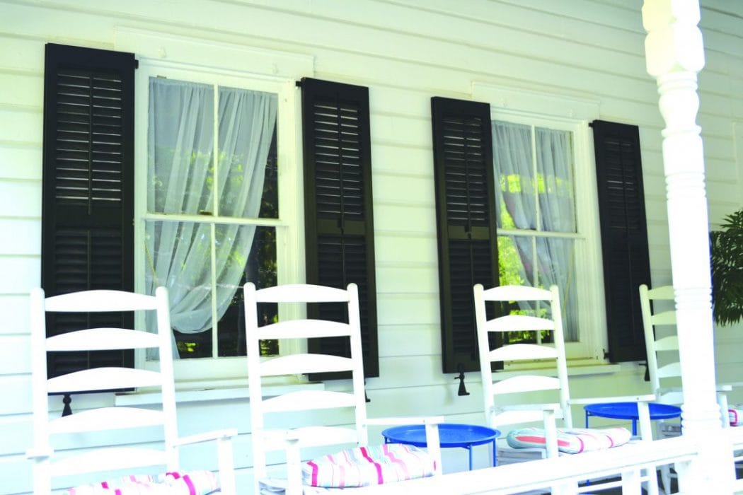 Georgetown shutter dogs in black powder coat, 6-1/4 inches, displayed on windows with white curtains. Sold in pairs.