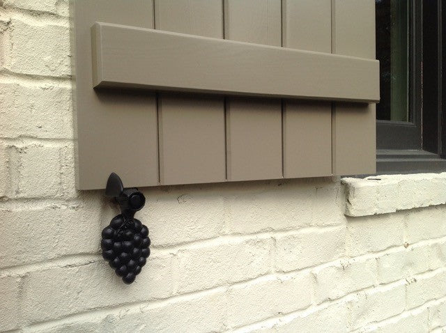 Black powder-coated cast iron shutter dogs in grape design, 6-1/4 inches, sold in pairs for securing shutters.