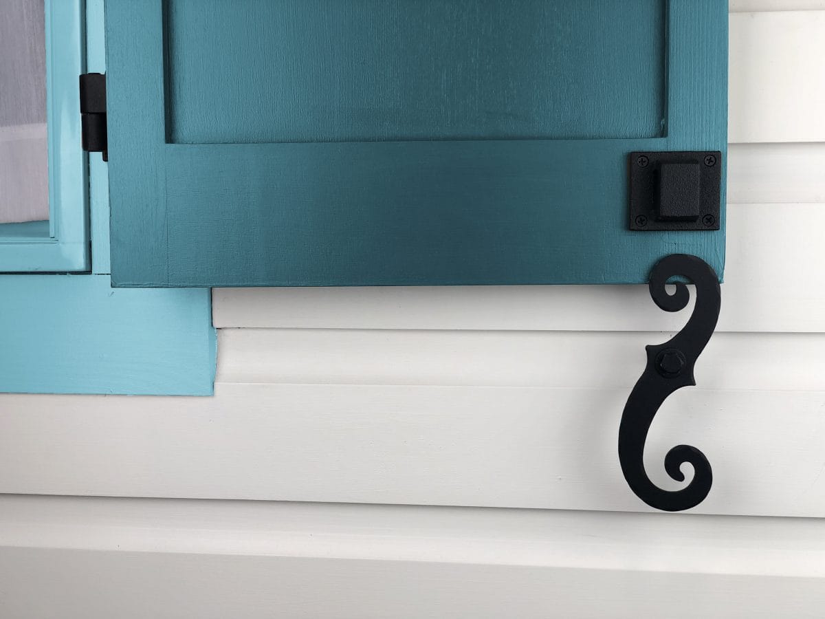 Stainless steel shutter dogs in black textured powder coat, 6-3/4 inches, holding a shutter open, sold in pairs.