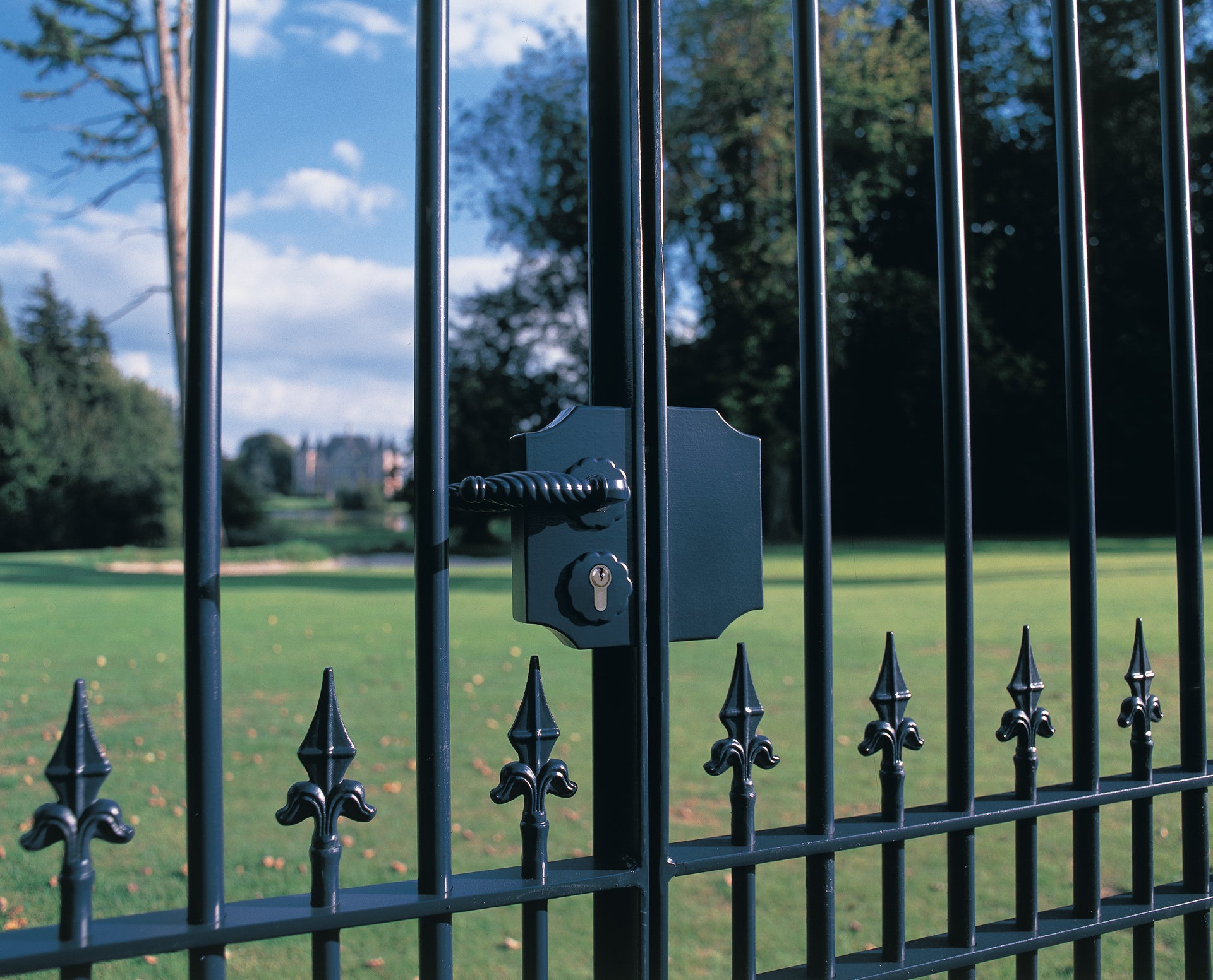 Small surface mounted ornamental gate lock in black finish for square or flat profiles, suitable for gates 3/8" to 2-3/8".