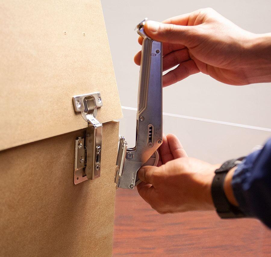 Soft close lid stay being installed on a cabinet, showcasing its lift assist feature and adjustable torque options.