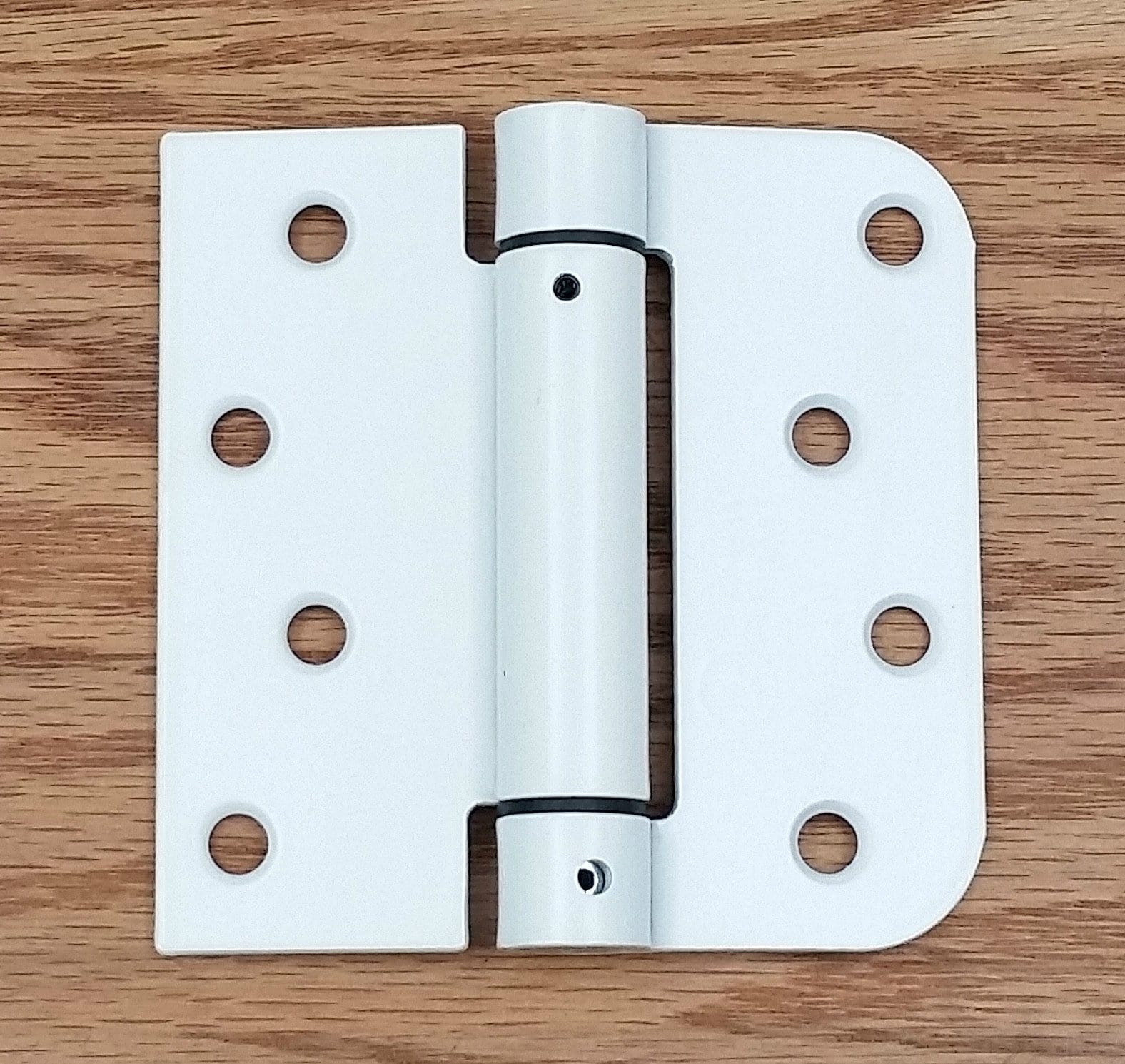 White 4-inch Penrod spring hinge with 5/8-inch square radius, designed for self-closing applications.