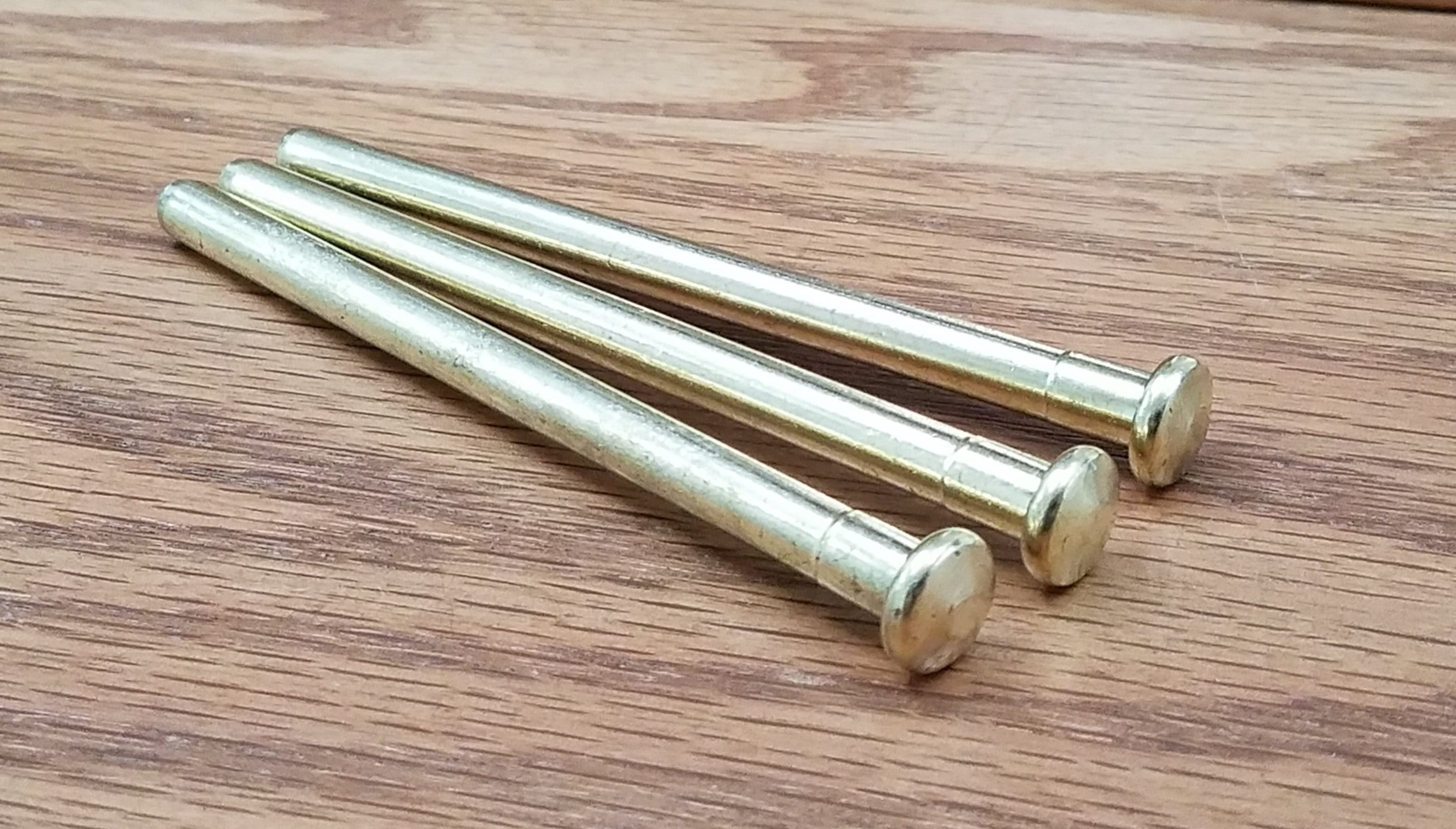 Bright brass hinge pins for doors in a 3-pack, designed for durability and smooth operation. Ideal for home improvement.
